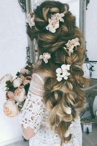 Loose twisted braid with flower hairstyle for engagement brides